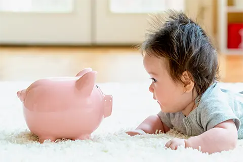 子どもと豚の貯金箱の写真